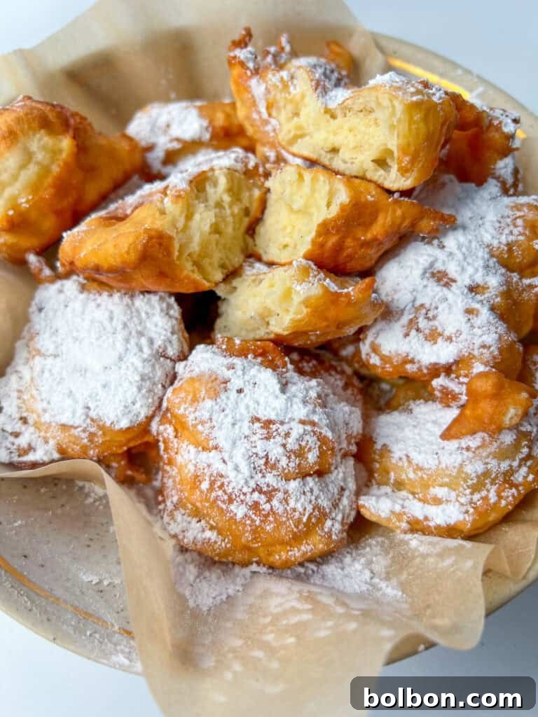 Golden Bulgarian Fritters 2 Golden, fluffy Mekitsi fried dough on a plate, ready to be served.