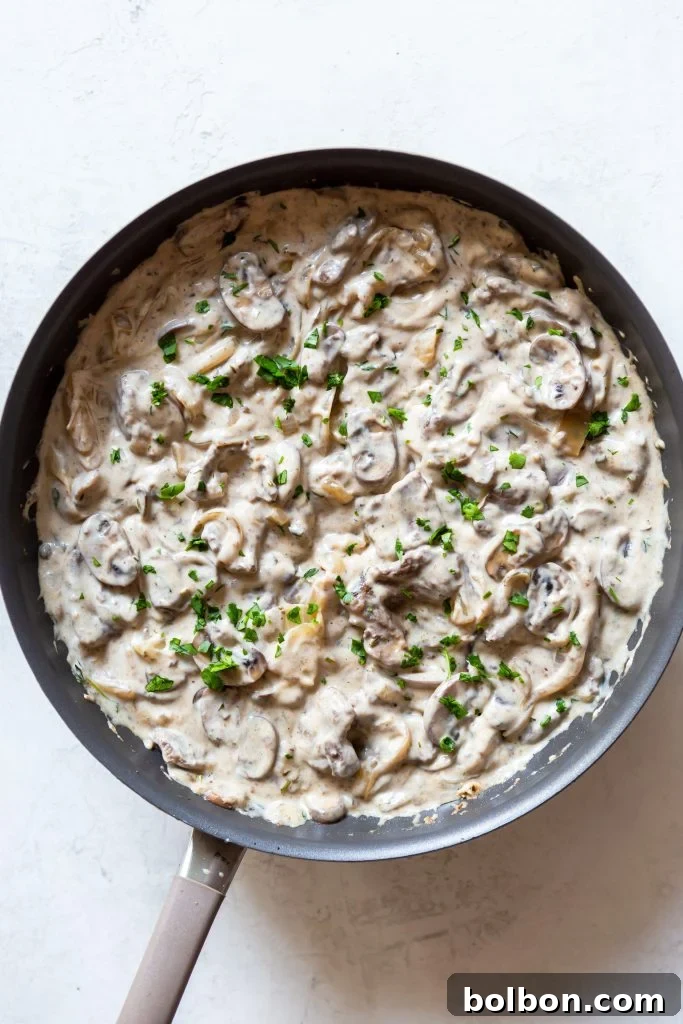 Creamy Beef Stroganoff simmering in a large sauté pan, ready to be served.