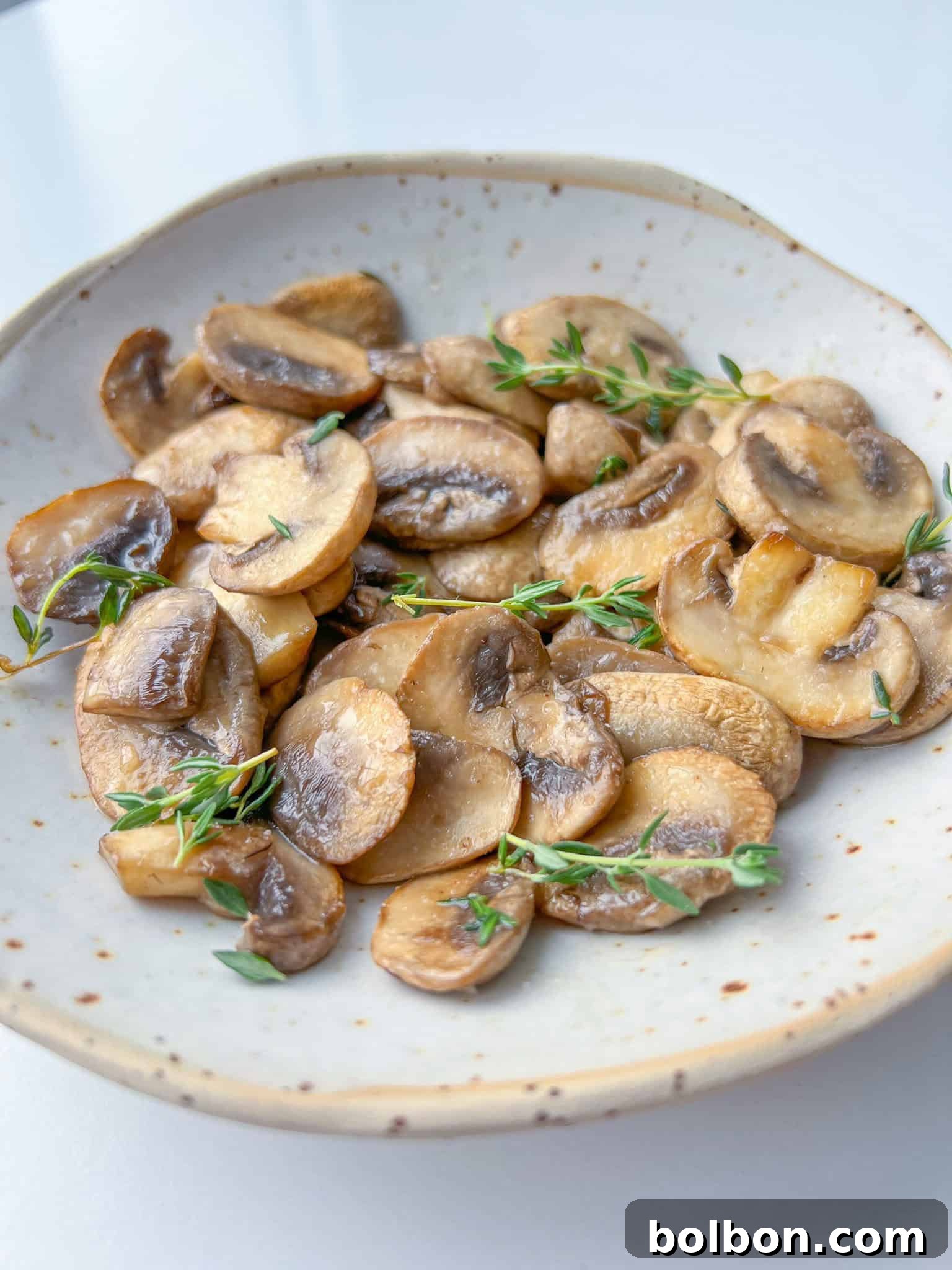 Mastering Mushroom Cooking 2 Perfectly cooked golden-brown mushrooms garnished with fresh herbs, ready to be served.