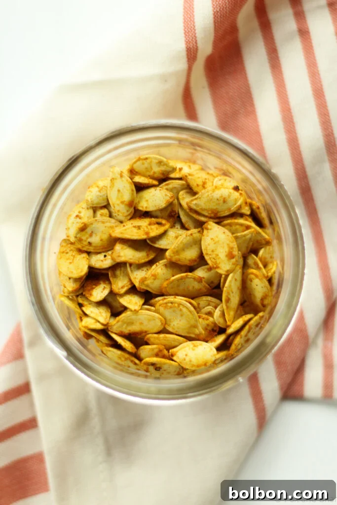 A bowl of freshly roasted curry pumpkin seeds, ready for snacking.