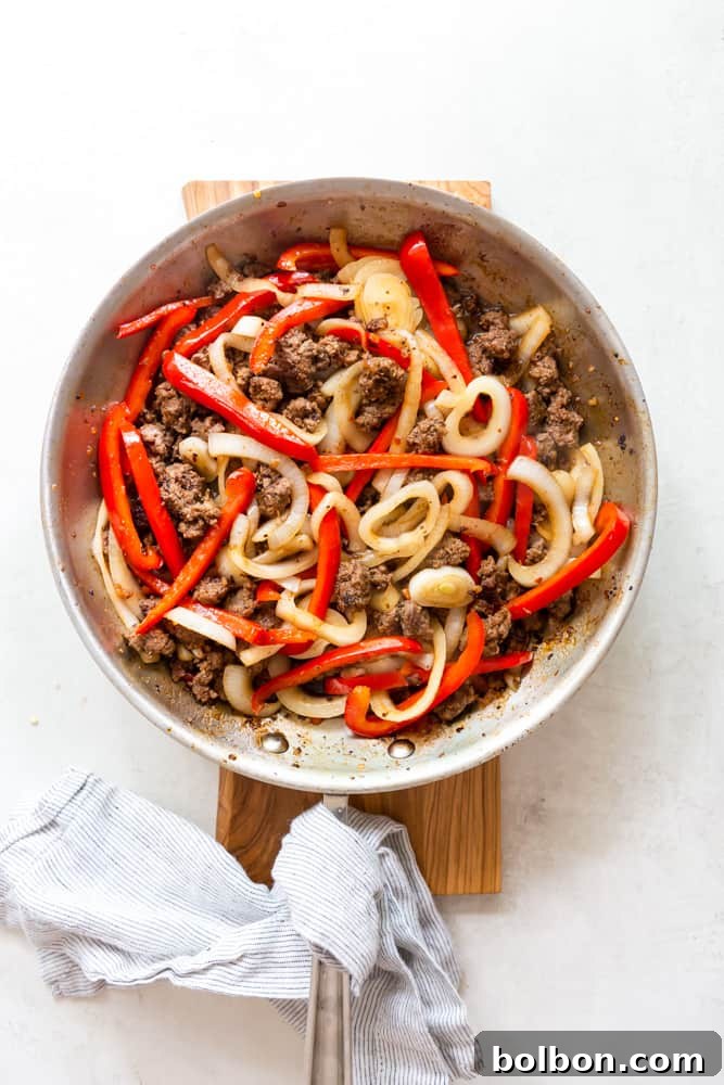 Spicy Thai Basil Beef 6 Garlic, onions, and bell peppers added to browning beef in a skillet for Thai basil beef.