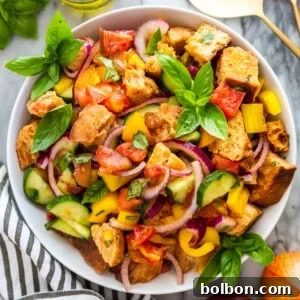 A vibrant Panzanella salad featuring colorful tomatoes, basil, and toasted bread, presented in a stylish bowl. Perfect for a summer meal.
