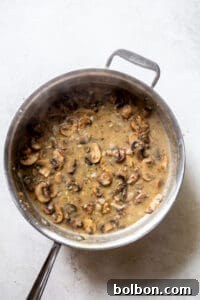White wine and broth added to the mushroom mixture.