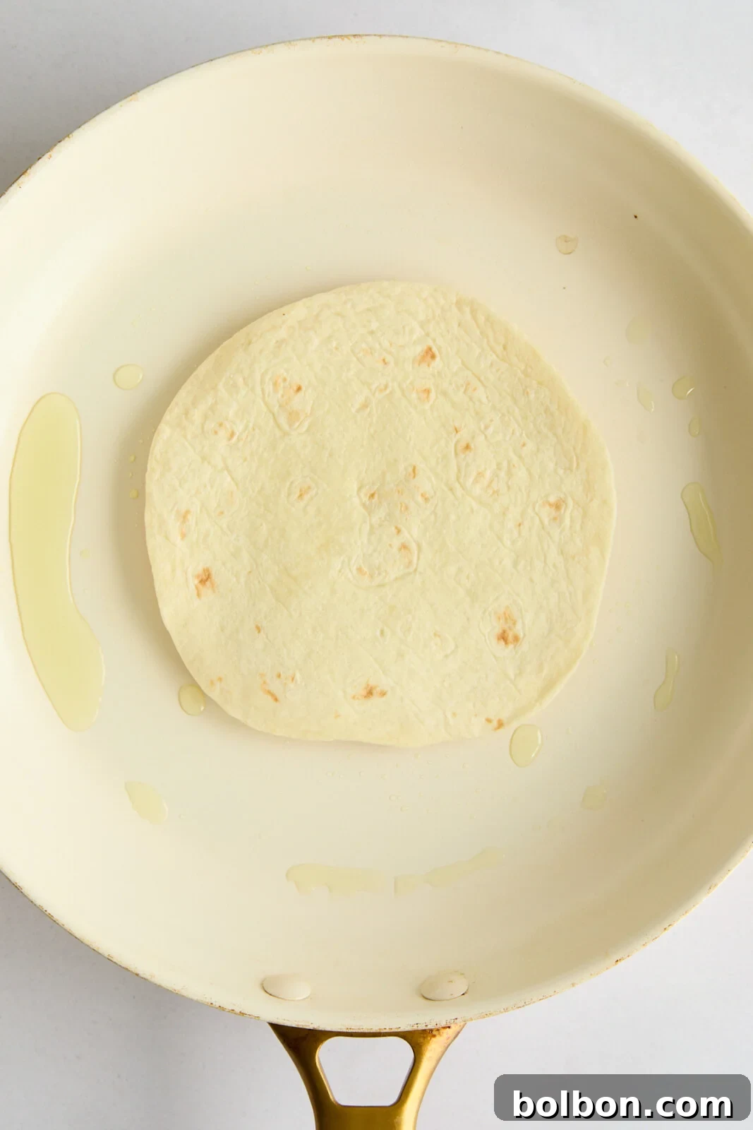 A Big Mac Smash Taco cooking in a hot pan, meat-side down, showcasing the sizzling beef patty pressing into the tortilla to achieve a perfect crust.