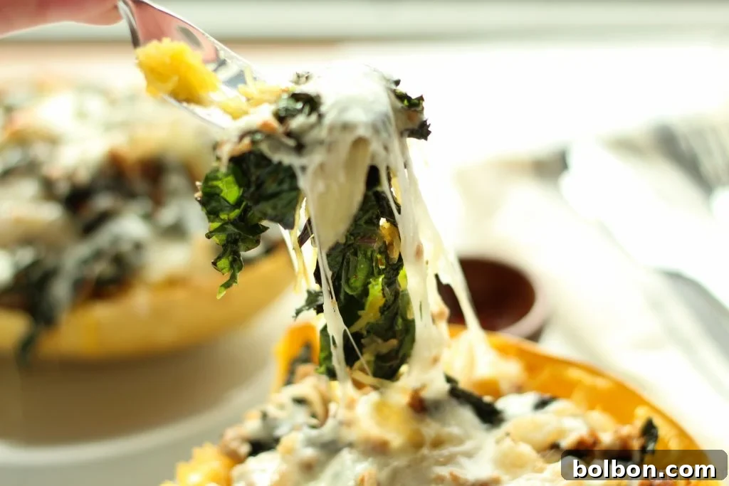 A close-up of the piping hot and cheesy Sausage and Kale Spaghetti Squash Boat.