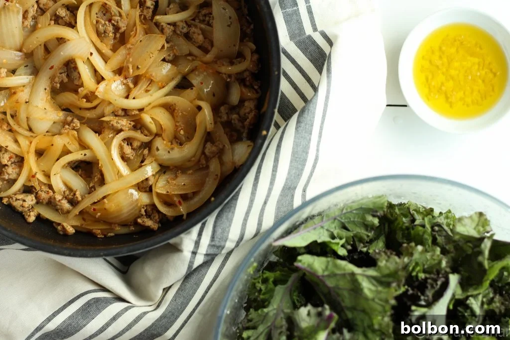 A pan filled with browned spicy Italian sausage and sliced onions for the filling.