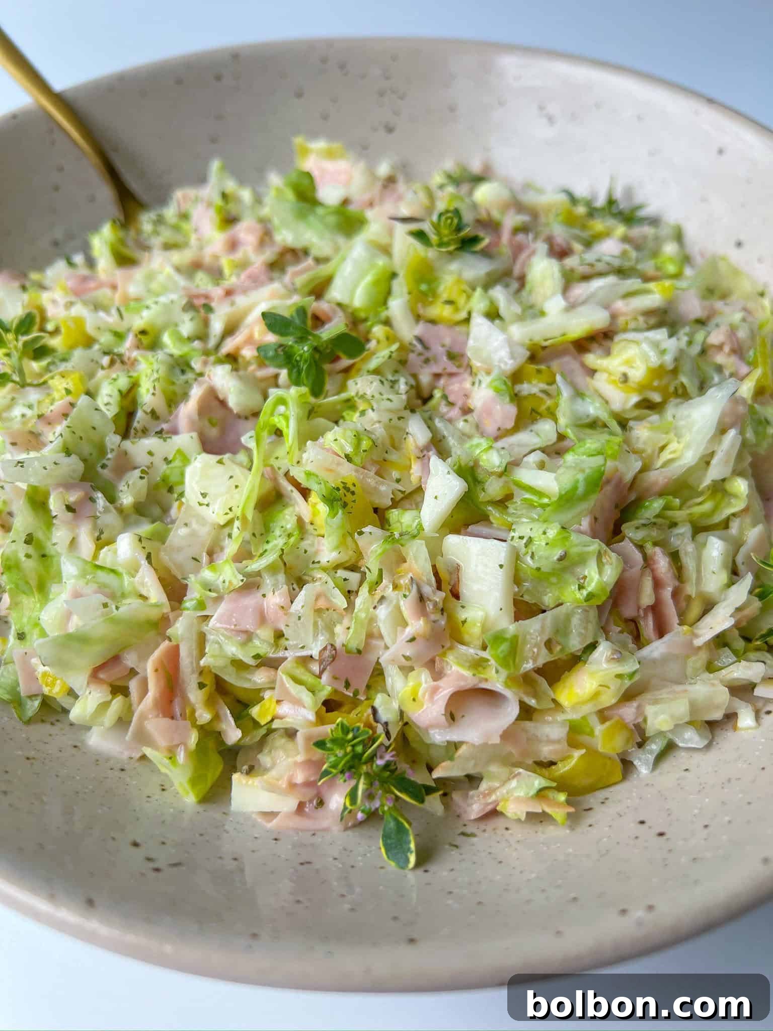 A vibrant Italian Chopped Salad overflowing with finely diced fresh greens, savory deli meats, and creamy cheese, dressed to perfection.
