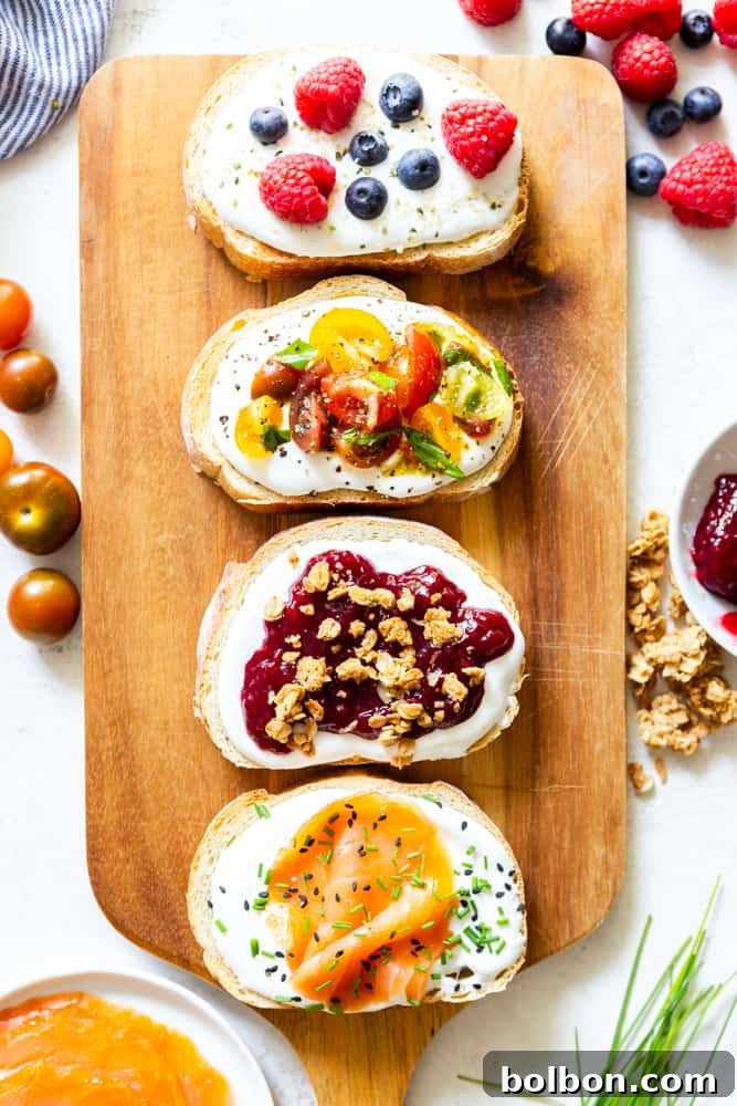 Several varieties of whipped cottage cheese toast on a wooden Board: 1. blueberries, raspberries and hemp hearts, 2. tomatoes bruschetta, 3. jam and granola, 4. smoked salmon, chives and black sesame seeds