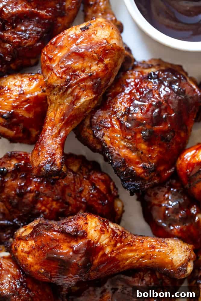 A close-up shot of grilled BBQ chicken thighs and drumsticks, showcasing their crispy, charred skin and luscious glaze. The vibrant colors and enticing textures highlight the succulence of the chicken, making it look incredibly appetizing.