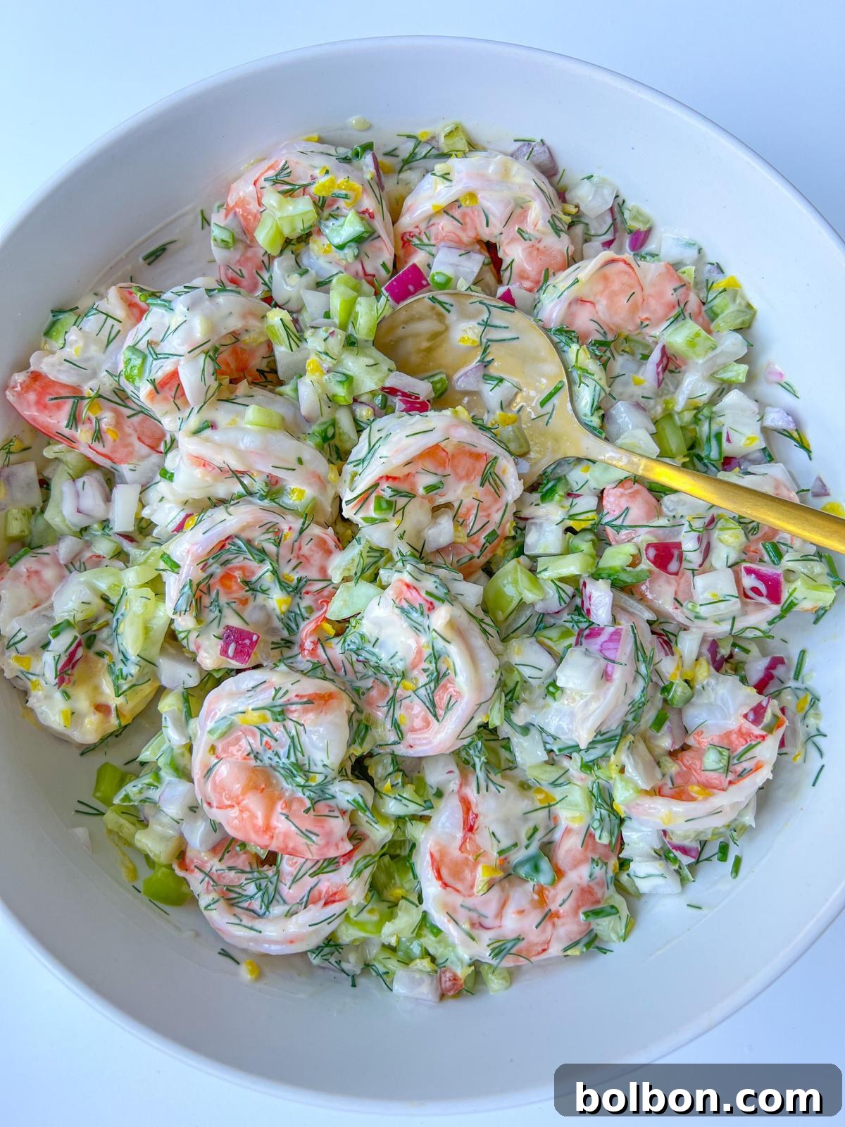 Creamy Shrimp Salad Delights 2 A vibrant close-up of Creamy Shrimp Salad, showcasing the juicy pink shrimp, crisp red onion, green chives, and dill, all coated in a rich, creamy dressing.