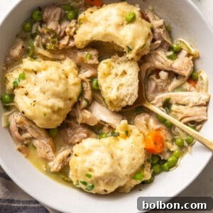A hearty bowl of Easy Chicken and Dumplings with a garnish of fresh parsley, steaming and ready to eat.