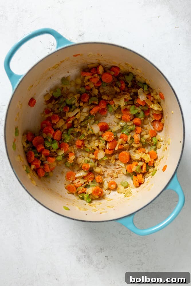 The softened carrots, celery, and onions in a Dutch oven, now coated with flour to create a rich roux for the stew's creamy base.