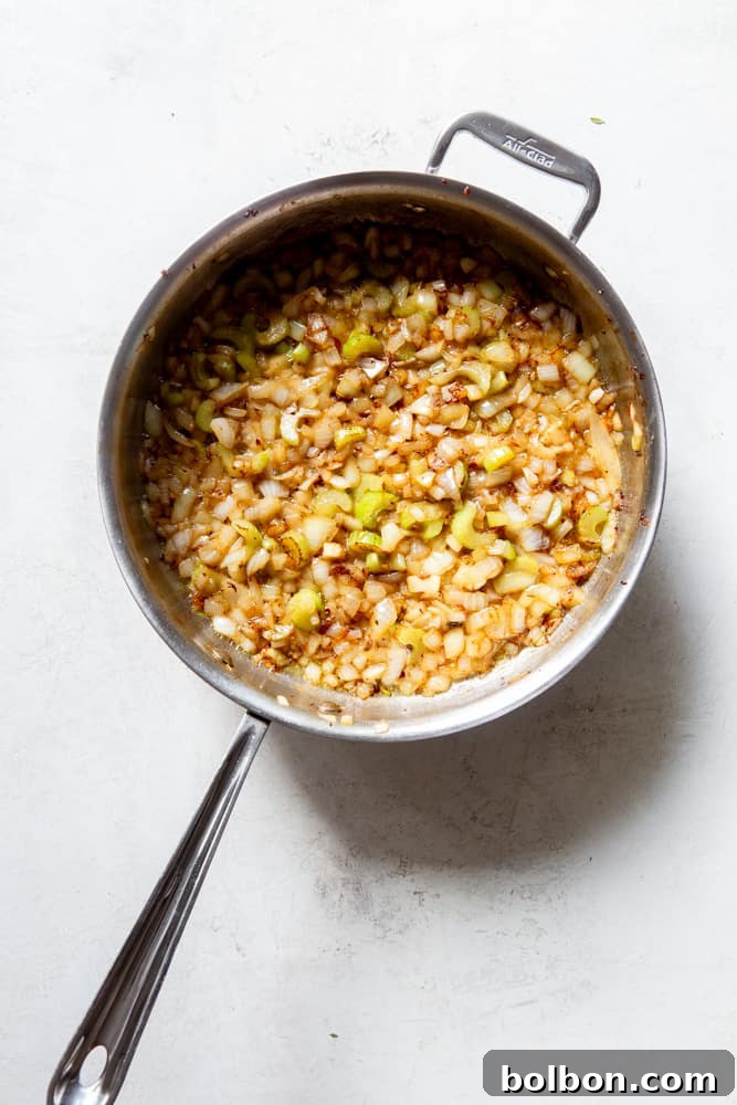 Timeless Savory Sausage Stuffing 7 Sauteed onions and celery cooking in a pan with butter.