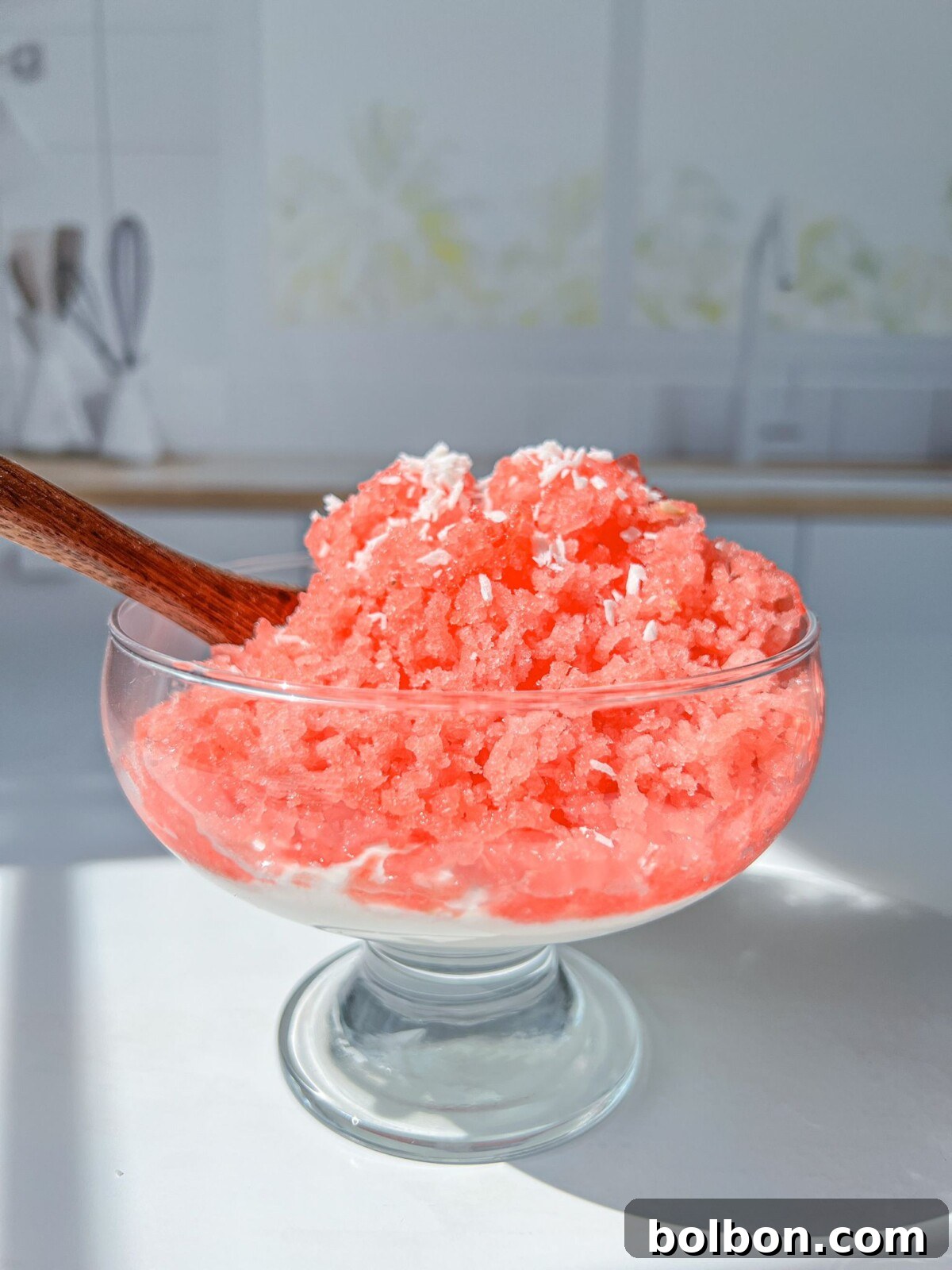 A vibrant bowl of watermelon shaved ice, topped with fresh mint and a drizzle of coconut cream, glistening under the summer sun.