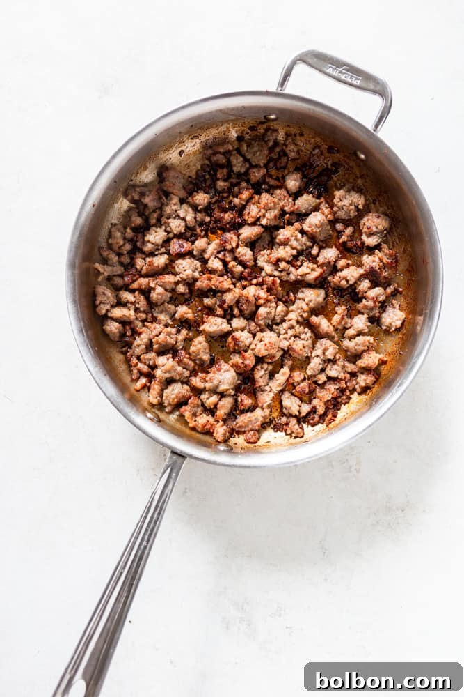 Hearty One-Pan Gnocchi & Sausage 4 Ground Italian sausage browning in a large stainless steel skillet, releasing its rich aromas and fat.