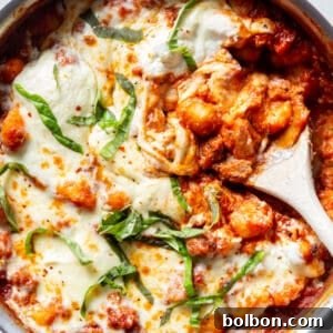 Finished Cheesy One Pot Gnocchi with Sausage, showing a bubbling, cheesy top and rich sauce.