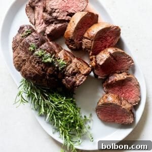 Slow Roasted Beef Tenderloin garnished with fresh herbs