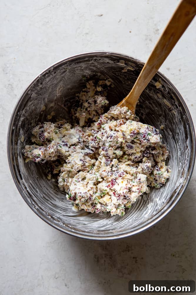 A bowl of creamy, mixed Cranberry Pecan Cheese Ball mixture, before being shaped into a festive ball and chilled.