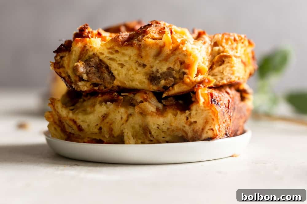A serving of Overnight Croissant Breakfast Casserole on a plate, showcasing its golden crust, savory sausage, and melted cheese.