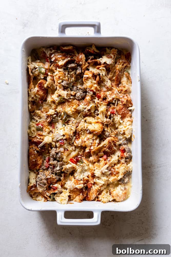 The unbaked Croissant Casserole in a baking dish, before the final cheese topping is added.
