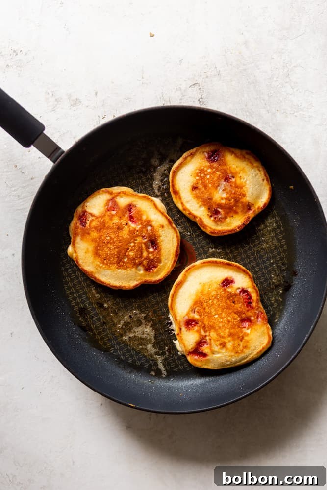 Strawberry pancakes in a non stick fryng pan