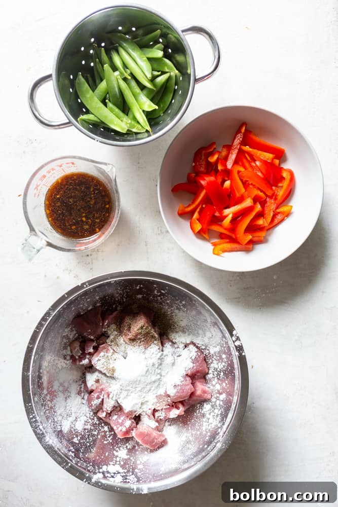 Sweet and Sticky Honey Garlic Pork Stir Fry 4 Ingredients for stir fry: Snap peas, sliced red bell pepper, stir fry sauce, pork cut into cubes in a bowl with cornstarch, salt and pepper.