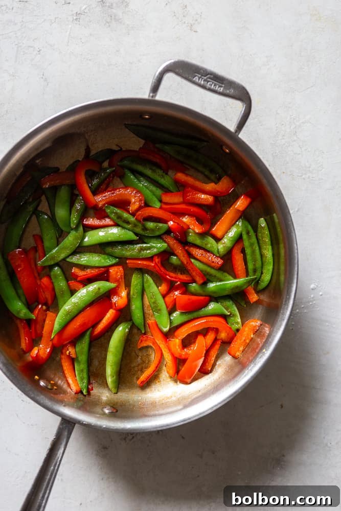 Sweet and Sticky Honey Garlic Pork Stir Fry 5 Snap peas and red bell peppers in a sauté pan