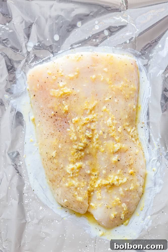 Halibut Filet before being baked, brushed with garlic butter on a foil lined baking sheet. 