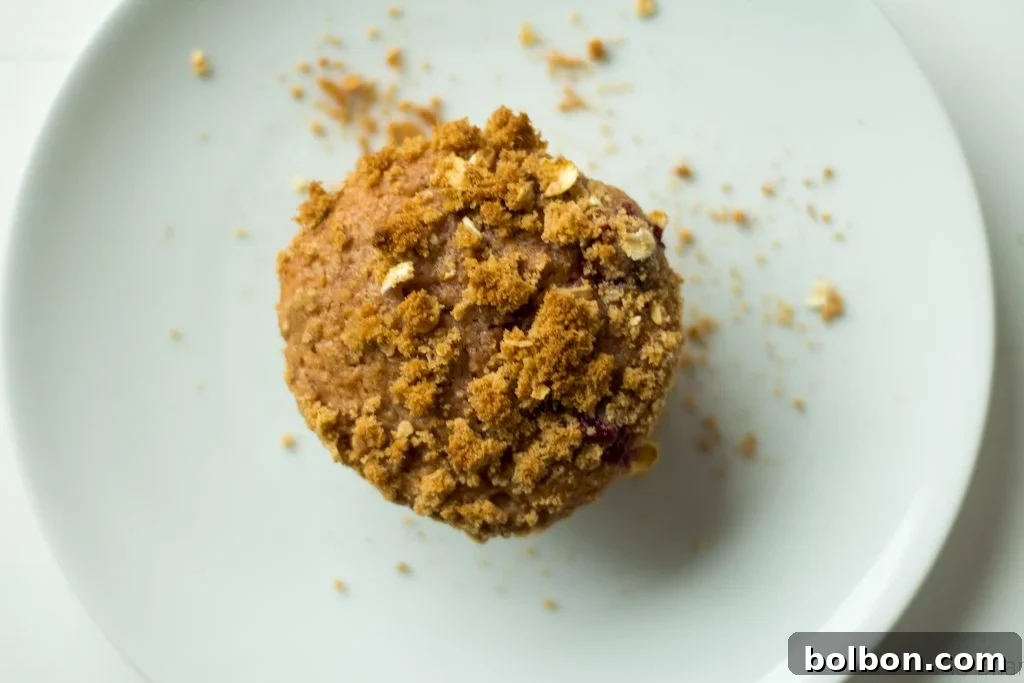 A stunning close-up of a cranberry orange muffin, showcasing its moist crumb and rich, fruity filling.