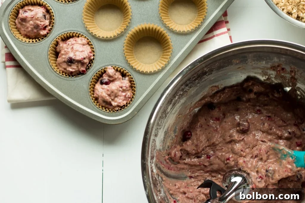 A fresh batch of cranberry orange muffins baked to perfection, showcasing their fluffy domes and crumble topping.