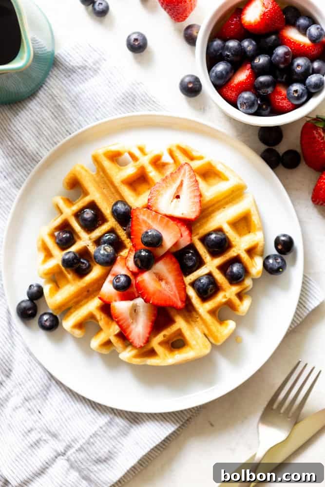 Buttermilk waffle topped with fresh fruit and maple syrup, ready to be enjoyed as a delightful breakfast.