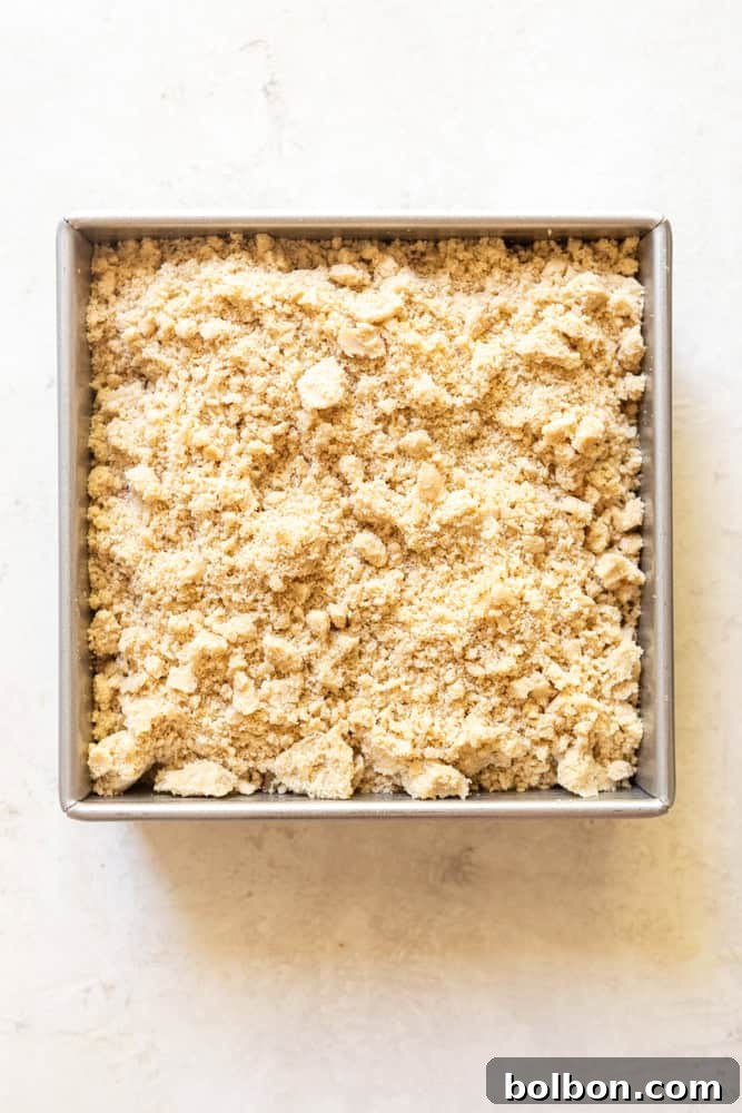 Homestyle Rhubarb Crumble 5 Square metal backing pan with rhubarb crumble before baking.