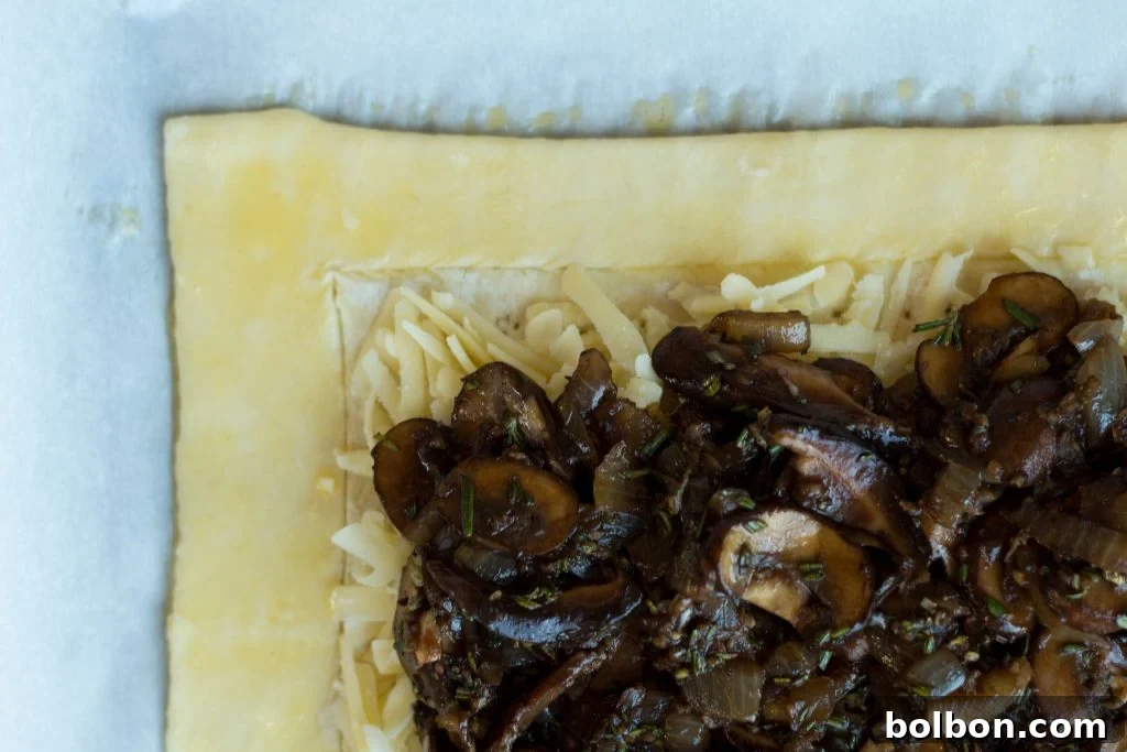 A freshly baked savory mushroom and gruyere tart, sliced and ready to serve.