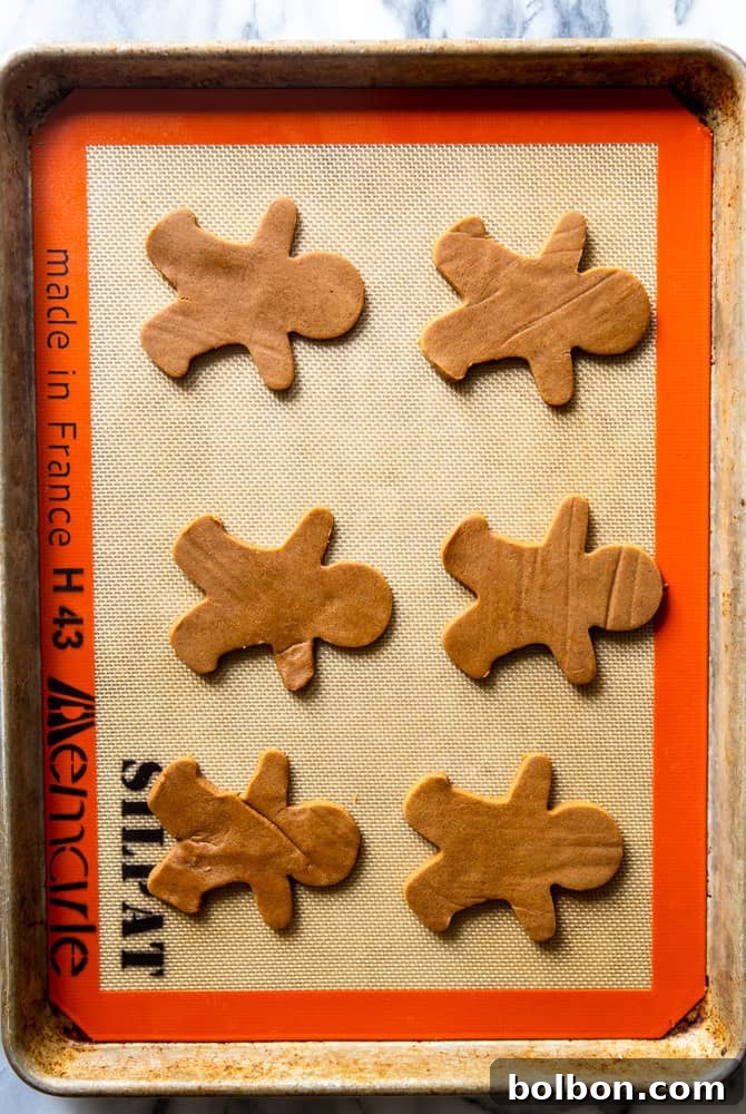 Gingerbread man cookies on a baking sheet before being baked.