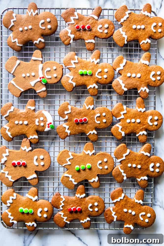 Decorated gingerbread people cookies on a cooling rack.