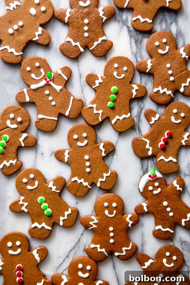 Decorated gingerbread people cookies on a marble slab.