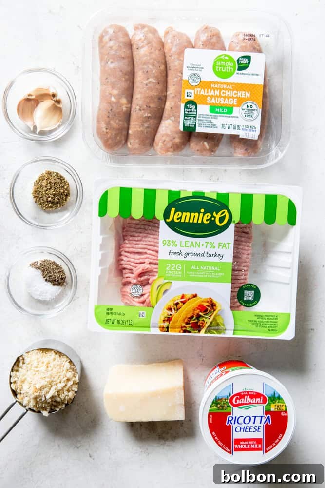 Ingredients for Turkey Ricotta Meatballs laid out: ground turkey, ground chicken or turkey sausage, garlic cloves, dried oregano, salt, pepper, panko bread crumbs, parmesan cheese, and a tub of ricotta cheese.