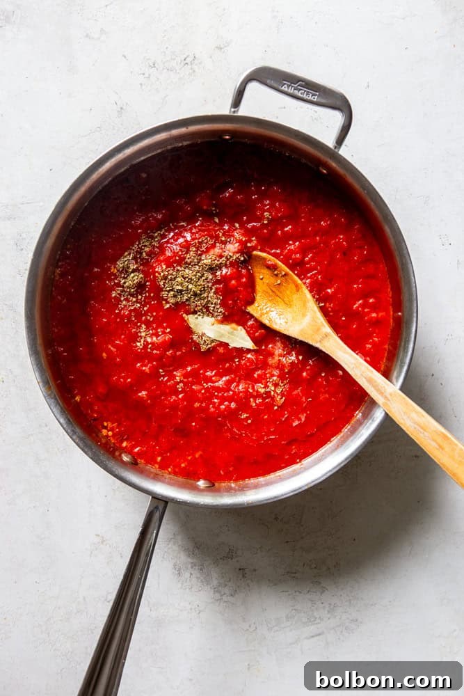 A skillet filled with bubbling, vibrant red Easy Marinara Sauce, ready to be served with meatballs or pasta.