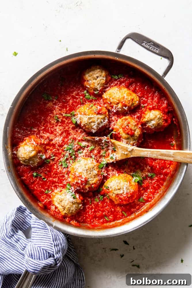Turkey Ricotta Meatballs simmering gently in a vibrant marinara sauce within a large skillet, ready to be served.