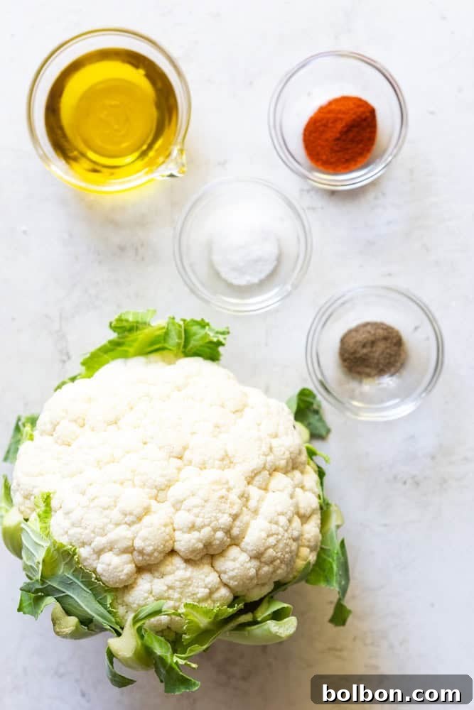 Basic ingredients for roasted cauliflower: fresh cauliflower, olive oil, salt, black pepper, and smoked paprika.