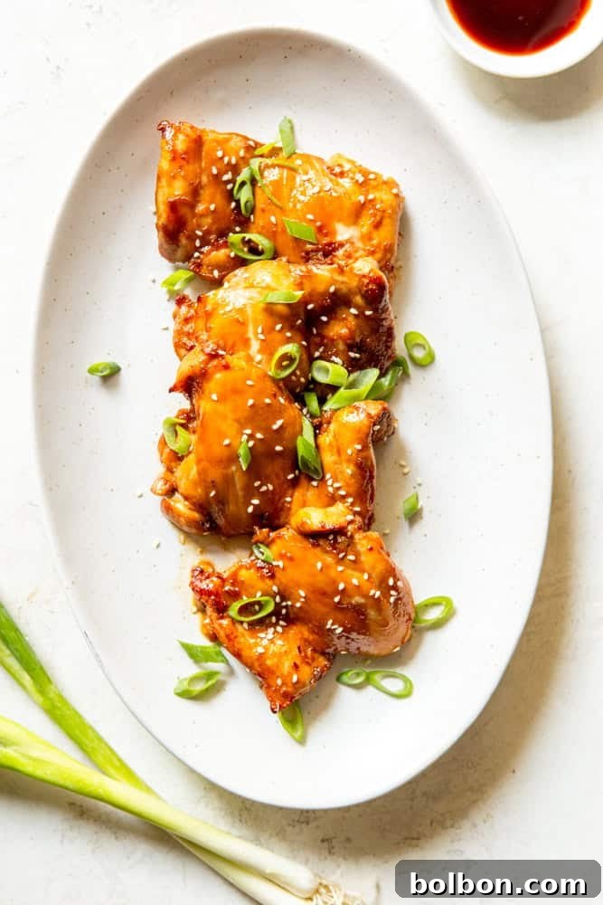 Perfectly glazed Baked Soy Ginger Chicken Thighs arranged on a white serving platter, ready to be served.