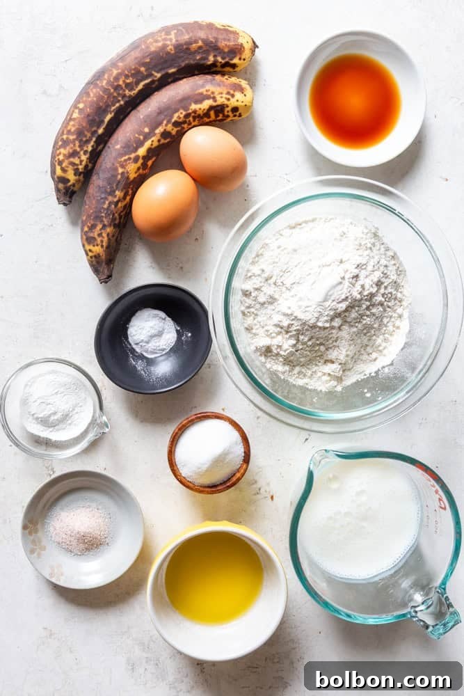 Velvet Banana Pancakes 3 A vibrant display of fresh ingredients for fluffy banana pancakes, including ripe bananas, buttermilk, eggs, flour, sugar, and butter, laid out on a kitchen counter.