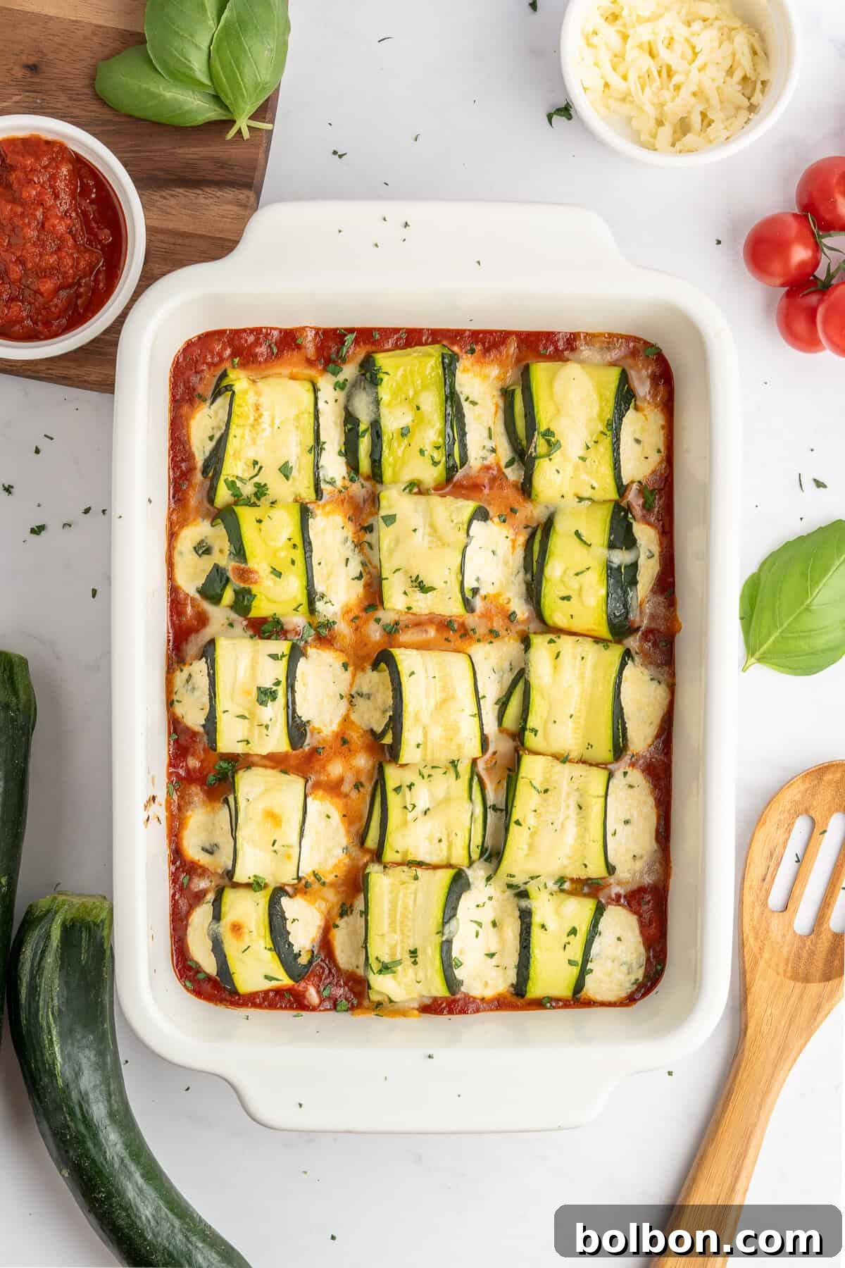 a tray full of baked zucchini lasagna rolls 