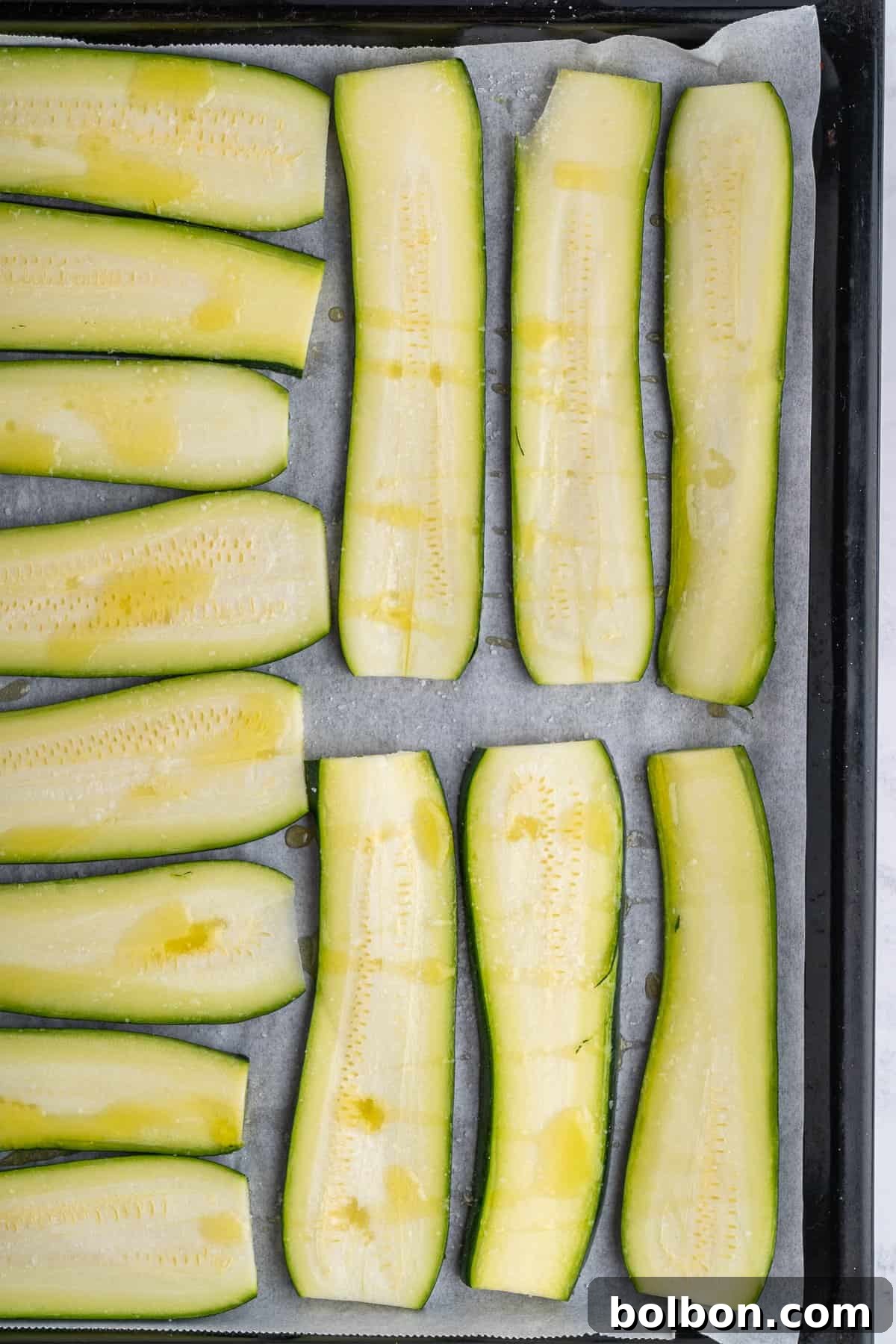 Picture of the zucchini on a baking sheet drizzled with olive oil 