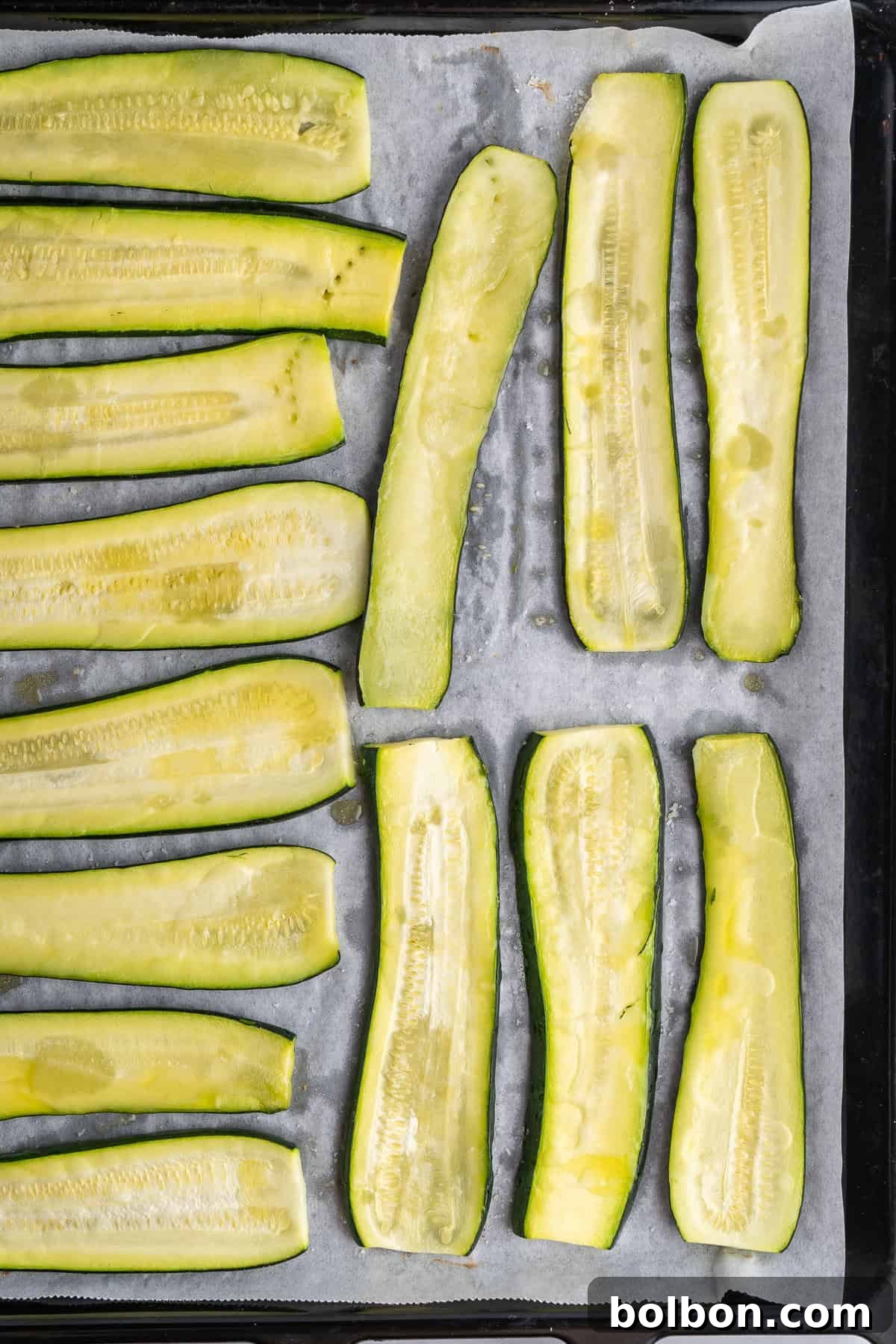 Picture of the zucchini on a baking sheet drizzled with olive oil 