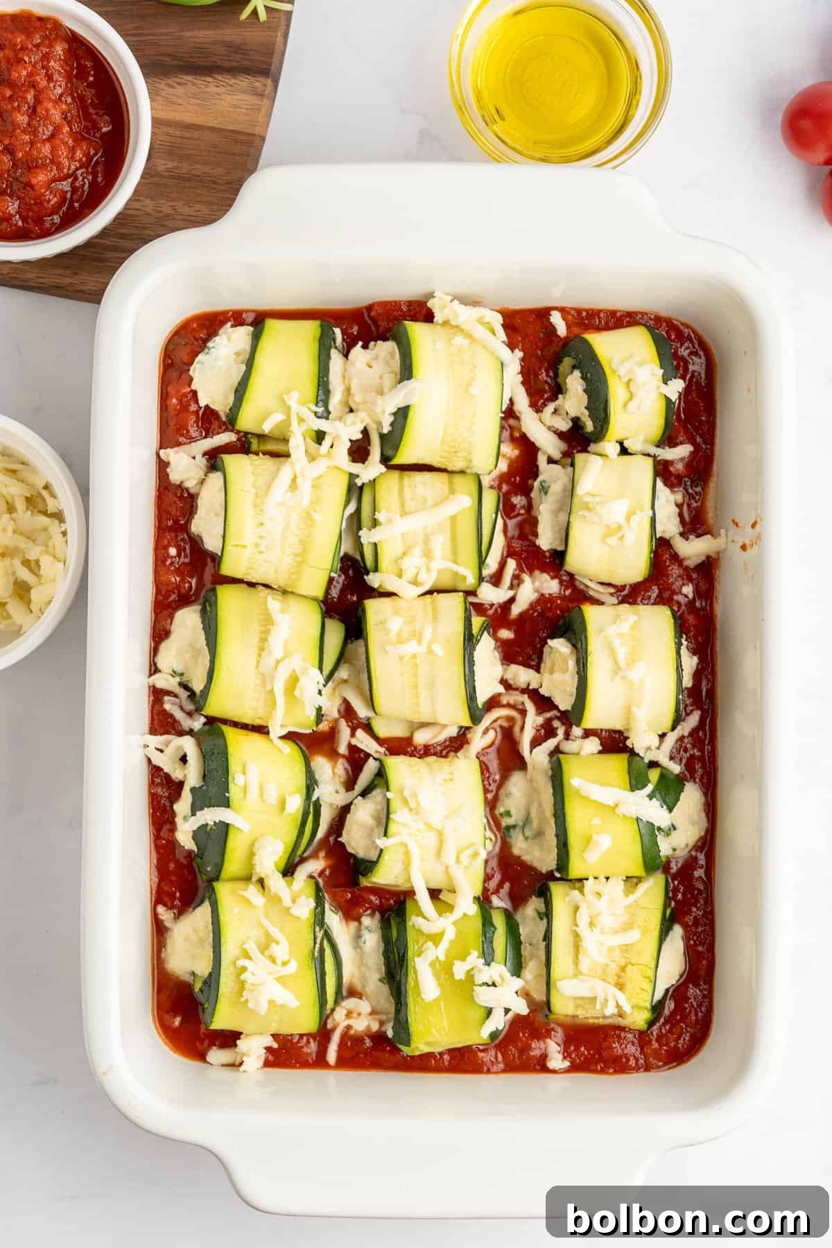 tray ready to go in the oven of the unbaked zucchini lasagna rolls