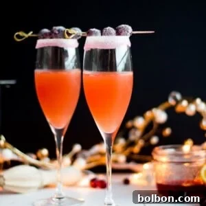 A stunning Cranberry Orange Cosmo served in a martini glass with sugared cranberries, illustrating the festive drink.