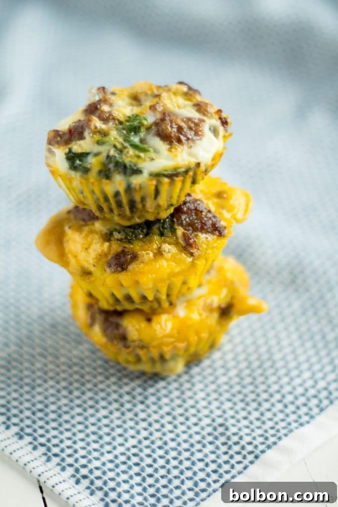 A serving of two sausage and kale egg muffins with fresh parsley garnish