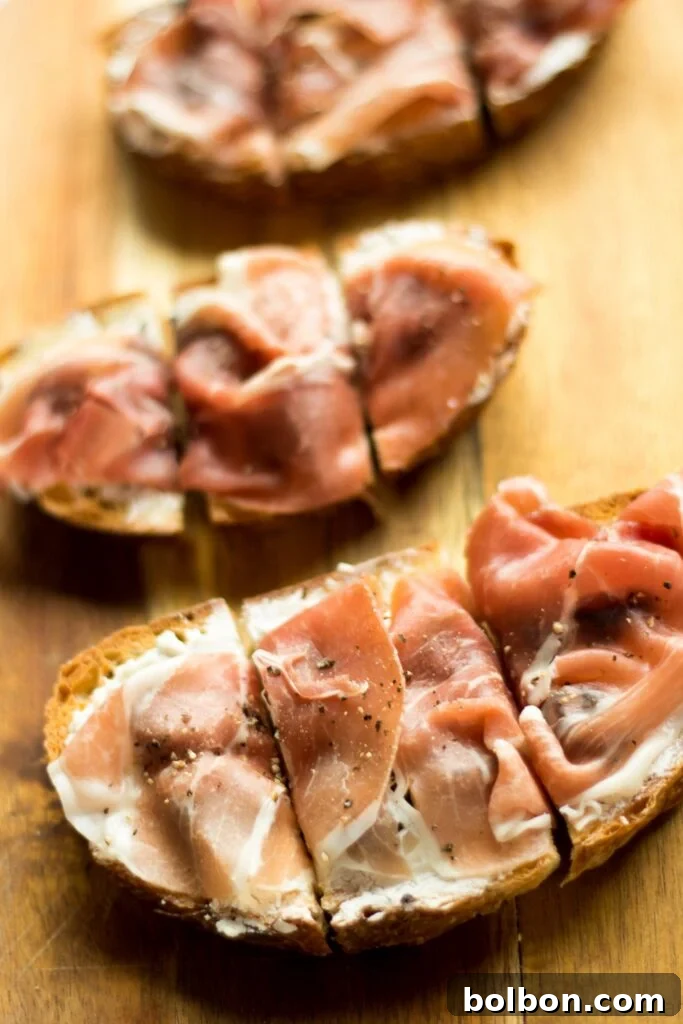 Fig, Prosciutto, and Creamy Chèvre Crostini 8 Beautifully arranged Fig, Goat Cheese, and Prosciutto Bruschetta on a rustic wooden board