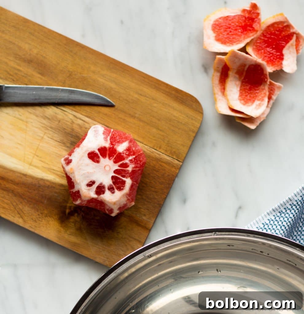 Hands demonstrating how to section a grapefruit for salad.